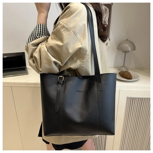 Borsa tote nera classica in pelle con logo mostrata in un accogliente ambiente domestico