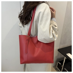 Detail of red leather tote bag with FASHION & BAGS logo and adjustable strap