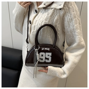 Detail of dark brown glossy leather crescent bag with Los Angeles 95 collegiate print