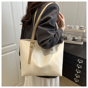 Dettaglio della borsa tote crema con testo moda e tracolla kaki regolabile