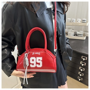 Close-up of red Los Angeles 95 print crossbody bag with silver woven chain charm