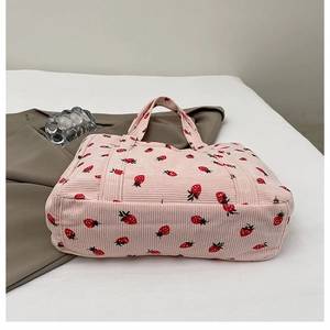 Nahaufnahme der rosa Cord-Tragetasche mit roten Erdbeer-Prints und weicher Textur