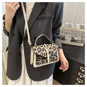 Detailed shot of leopard print handbag with cream leather trim and gold metal buckle