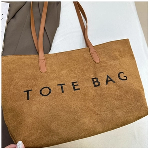 Vue détaillée du sac cabas en velours côtelé marron avec broderie TOTE BAG et anses
