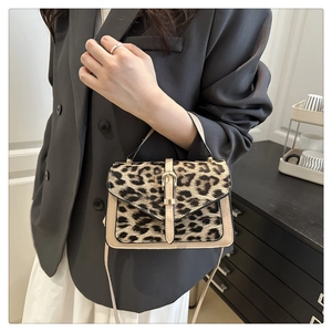Detailed view of leopard print flap and beige leather texture on the small crossbody bag