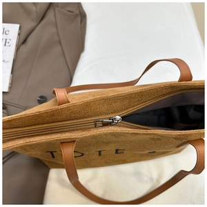 Détail de la fermeture éclair en métal sur un sac fourre-tout en velours côtelé marron