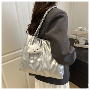 Detail of silver metallic tote bag with braided handle and plush cloud charm accessory