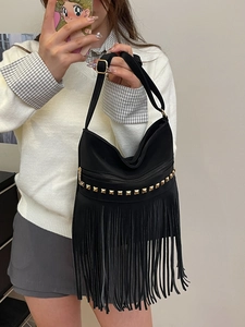 Large black tassel tote bag with gold metal rivets and adjustable strap for women