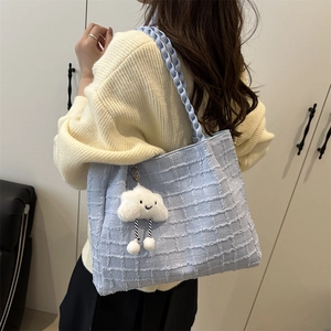 Detail of light blue tote bag with textured grid fabric and white cloud pendant