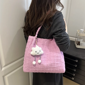 Detailed texture of pink tweed tote bag featuring a cute cloud plush pendant with smile