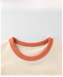 Close-up of ribbed orange neckline and cotton fabric on kids cartoon bear t-shirt