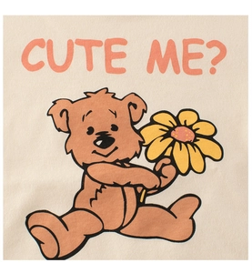 Close-up of beige knit fabric featuring a cute brown bear holding a flower and pink text