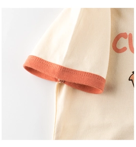 Detailed close-up of ringer tee sleeve with orange contrast trim and fine stitching