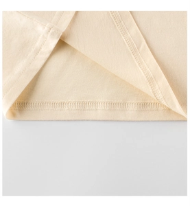 Detailed macro view of the neat hem stitching and cotton fabric texture on kids t-shirt