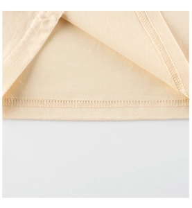 Close-up of double-needle stitching on beige cotton kids T-shirt showing fabric texture