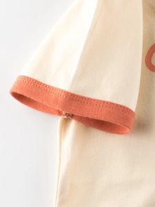 Short sleeve T-shirt for kids with contrast ribbed orange cuffs and cream knit fabric