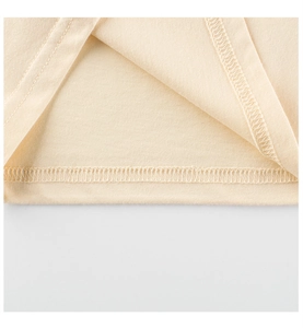 Detailed view of durable double-needle stitching on cream cotton baby T-shirt sleeve
