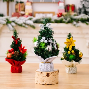 Three desktop mini Christmas trees in gold silver and red with bows and festive decorations