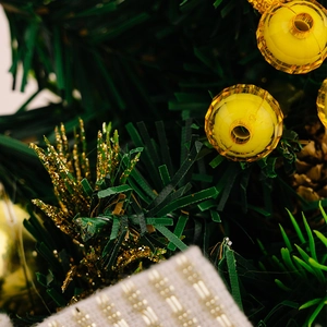 Macro shot of artificial pine needles and yellow faceted beads on a mini Christmas tree