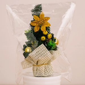 Detailed view of mini desktop Christmas tree with gold ornaments and striped base