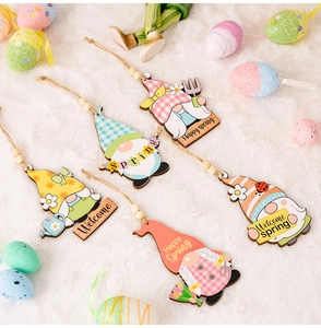 Detail of Easter wooden gnomes set with spring motifs on a white plush background