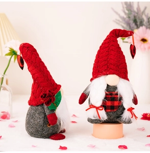 Detail of couple Valentine gnomes with red knit hats, heart ornaments and rose accessory