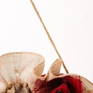 Macro shot of rustic red and natural burlap fabric heart wreath texture with jute rope