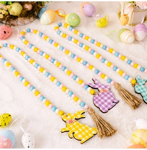 Close-up of Easter wooden bead garland with rabbit tag and jute tassel on white fur