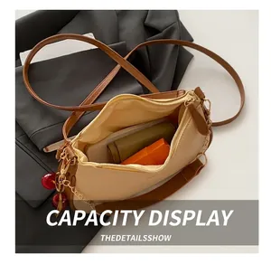 Detail view of beige pebbled leather crossbody bag showing interior storage capacity