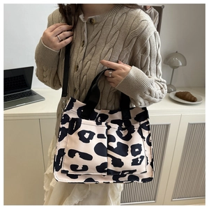 Leopard print tote bag detail showing dual black handles and front storage pockets