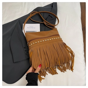 Détail du sac bandoulière en cuir caramel avec franges et clous dorés élégants
