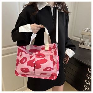 Detail of canvas bag featuring pink animal print with adjustable crossbody shoulder strap