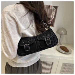 Detail der schwarzen Baguette-Tasche mit Leopardenmuster und Metallschnallen