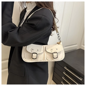 Detail der cremefarbenen Vintage-Schultertasche mit Doppeltaschen und Metallkette
