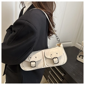 Detailansicht der weißen Schultertasche mit zwei strukturierten Taschen und Metallschnallen
