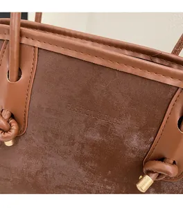 Macro detail of brown tote bag showing smooth PU leather texture and knotted handle