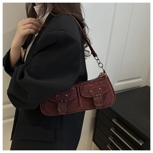 Detailansicht der kastanienbraunen Wildleder-Baguette-Tasche mit Metallschnallen