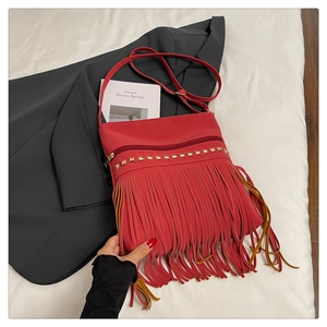 Détail du sac à bandoulière rouge à franges avec clous et texture en cuir PU