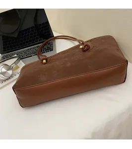Detailed top view of deep brown tote bag with suede panels and gold-tone hardware