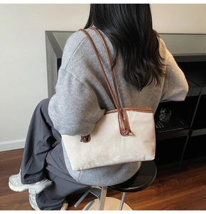 Beige suede tote bag with brown leather straps and metal side knot detail for commuting