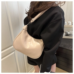 Detailed view of the cream white crescent shoulder bag with silver metal buckles