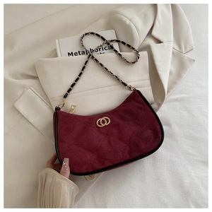 Macro view of vintage wine red quilted handbag with golden chain strap and buckle