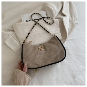 Close-up of khaki suede crossbody bag with quilted patterns and gold metal buckle
