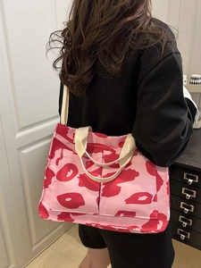 Pink abstract pattern canvas tote bag with shoulder straps worn by model for daily use