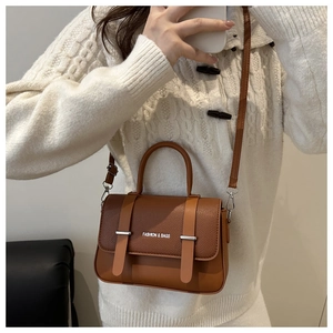 Détail du sac boîte marron caramel en cuir grainé avec sangles décoratives fines