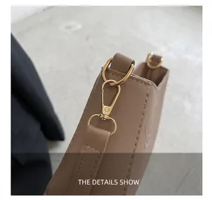 Close-up of golden metal hardware and strap connector on khaki leather handbag