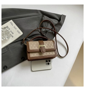 Detailed view of mini square bag with geometric texture and smartphone for size reference