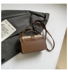 Flat lay of brown panelled handbag with beige diamond quilt and grey blazer detail