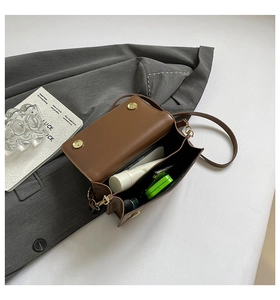 Internal view of brown flap crossbody bag showing capacity for phone and small accessories