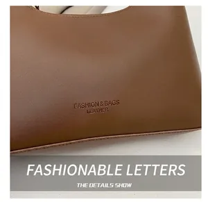 Close-up of brown textured leather underarm bag with Fashion & Bags embossed lettering